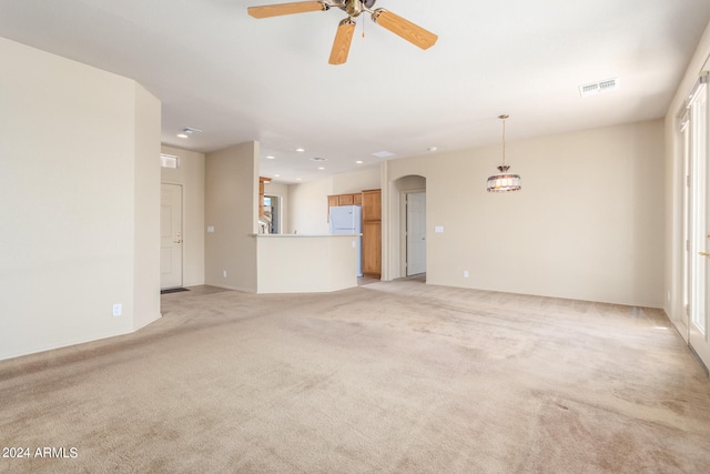 unfurnished living room featuring ceiling fan and light colored carpet