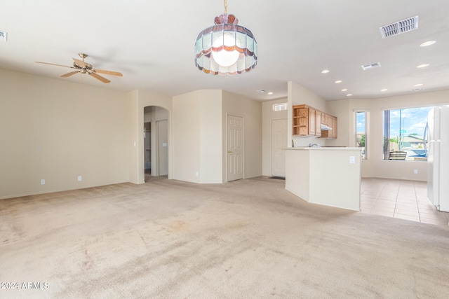 unfurnished living room featuring ceiling fan and light colored carpet