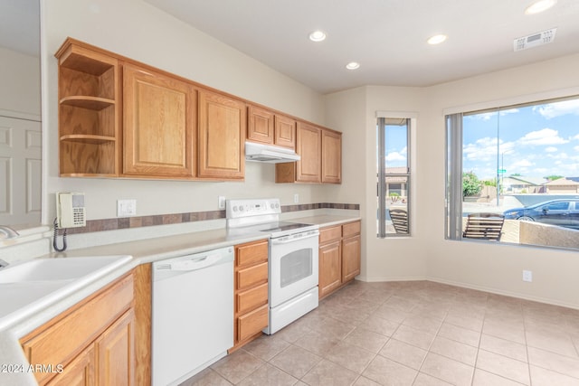 kitchen featuring sink, light tile patterned floors, and white appliances