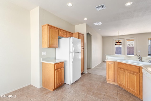 kitchen with white appliances, light tile patterned flooring, sink, and decorative light fixtures