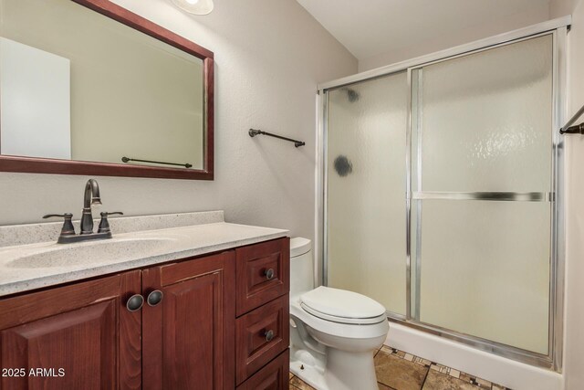 full bath featuring toilet, a stall shower, and vanity