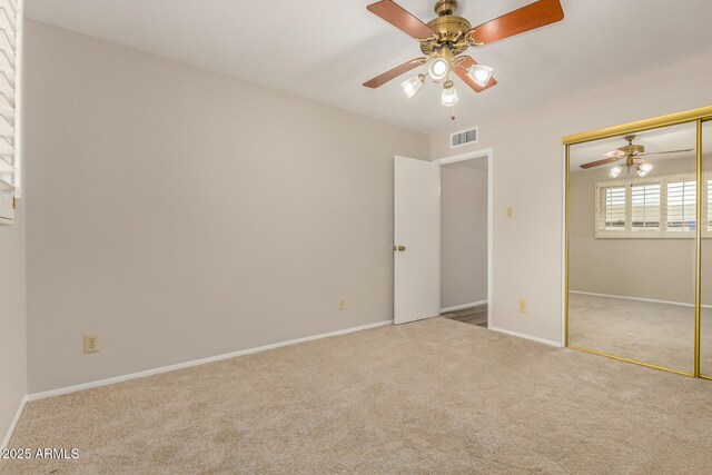 unfurnished bedroom featuring carpet, a closet, baseboards, and a ceiling fan