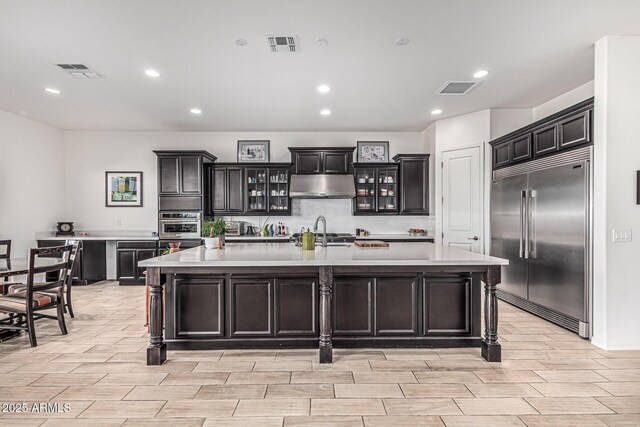 7813 S 43rd Pl, Phoenix, AZ 85042 - kitchen featuring stainless steel built in fridge, wood tiled floors, light countertops, a spacious island, and recessed lighting