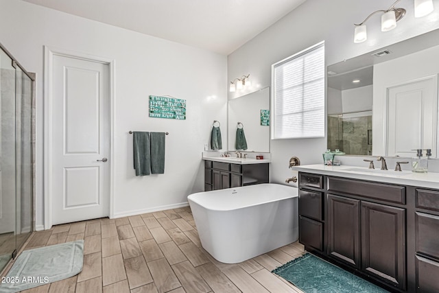 7813 S 43rd Pl, Phoenix, AZ 85042 - bathroom with a shower stall, two vanities, a freestanding tub, wood tiled floors, and baseboards