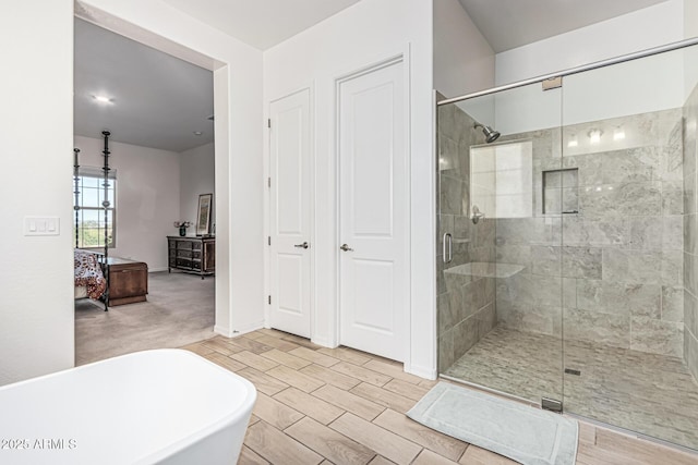 7813 S 43rd Pl, Phoenix, AZ 85042 - ensuite bathroom featuring a shower stall, a freestanding tub, baseboards, and wood finish floors