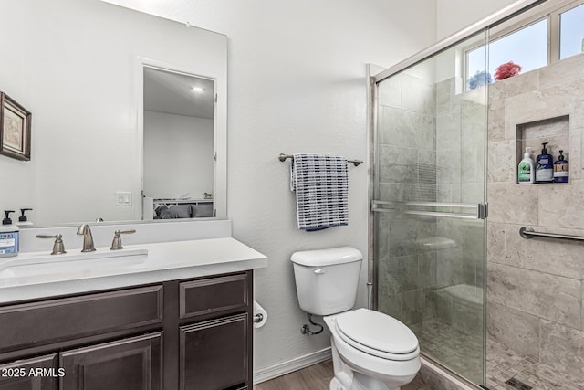 7813 S 43rd Pl, Phoenix, AZ 85042 - ensuite bathroom featuring vanity, toilet, a stall shower, wood finished floors, and baseboards