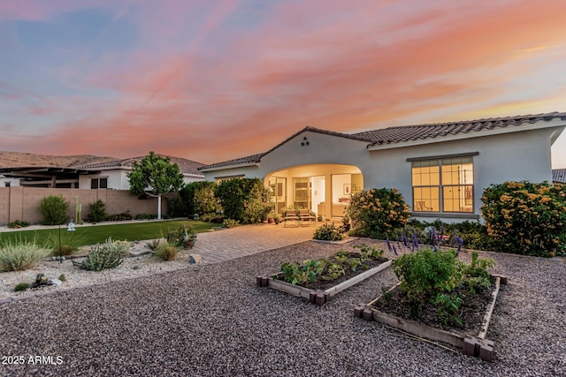 7813 S 43rd Pl, Phoenix, AZ 85042 - mediterranean / spanish-style house featuring a garden, a tile roof, stucco siding, and a patio