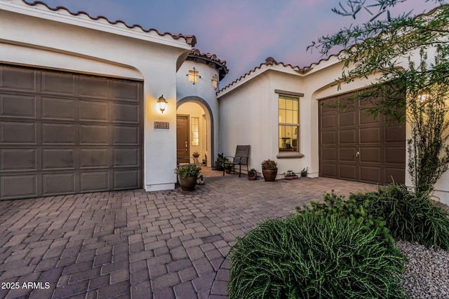 7813 S 43rd Pl, Phoenix, AZ 85042 - mediterranean / spanish-style house with decorative driveway, an attached garage, stucco siding, and a tile roof