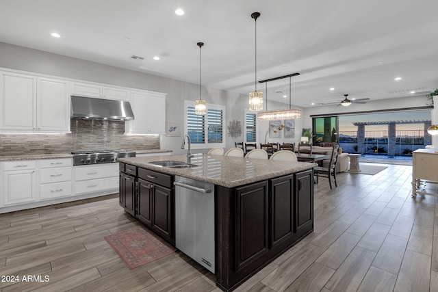 kitchen featuring appliances with stainless steel finishes, ceiling fan, sink, pendant lighting, and an island with sink