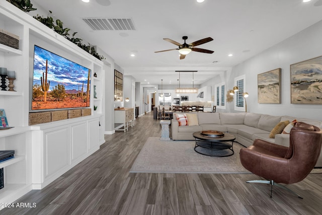 living room with dark hardwood / wood-style floors, ceiling fan, and built in features