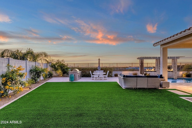 yard at dusk featuring outdoor lounge area and a patio