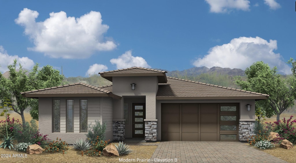 prairie-style home featuring a mountain view and a garage