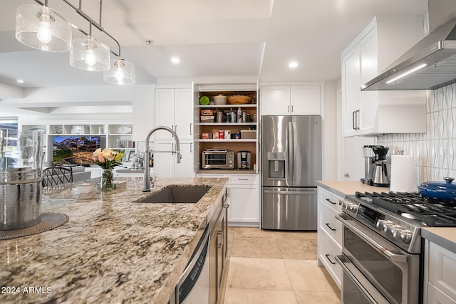 kitchen with white cabinetry, sink, wall chimney exhaust hood, pendant lighting, and appliances with stainless steel finishes