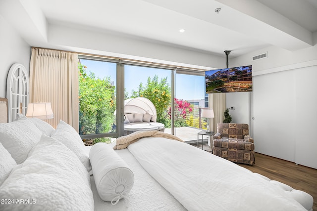 bedroom with access to outside, multiple windows, and hardwood / wood-style floors