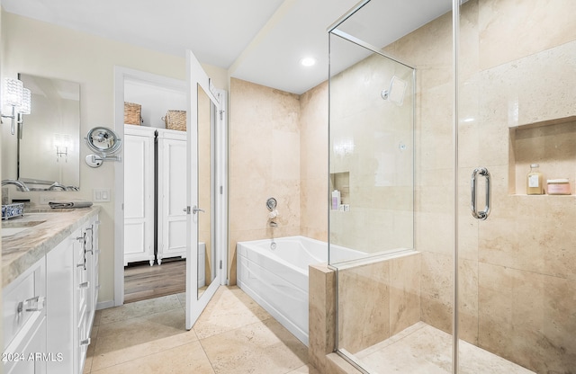 bathroom with tile patterned floors, vanity, and plus walk in shower