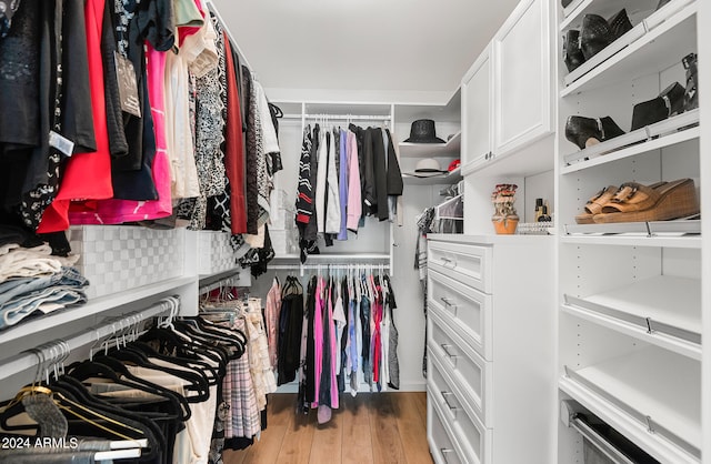 walk in closet with light hardwood / wood-style floors