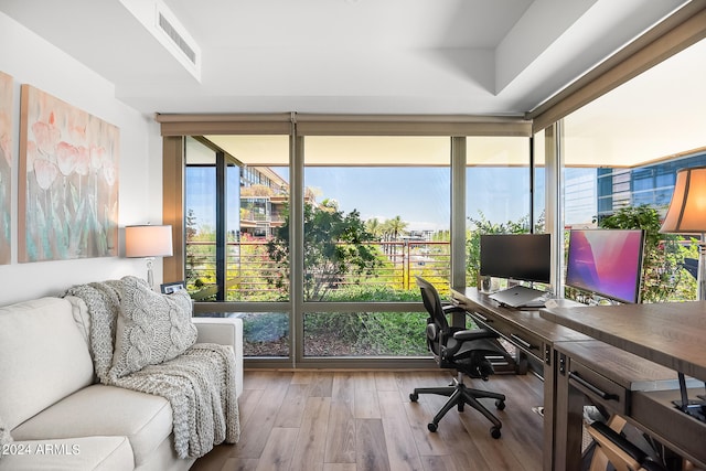 office area with hardwood / wood-style flooring and expansive windows