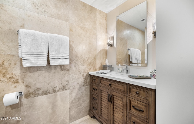 bathroom featuring vanity and tile walls