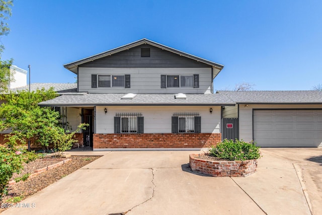 traditional home featuring a shingled roof, an attached garage, driveway, and brick siding