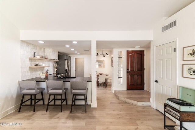 5505 E Mclellan Rd Unit 111, Mesa, AZ 85205 - kitchen featuring a kitchen breakfast bar, open shelves, a peninsula, dark countertops, and stainless steel refrigerator with ice dispenser