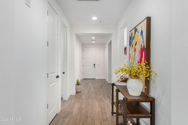 hallway with light hardwood / wood-style floors