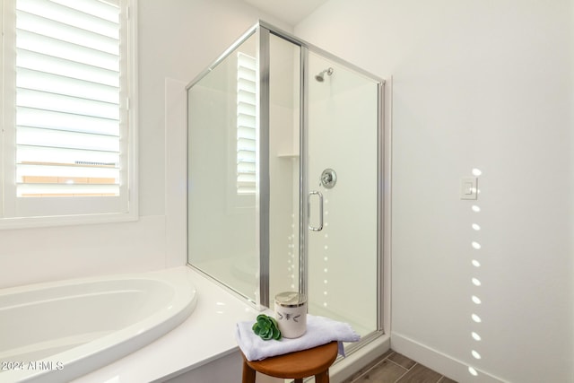 bathroom featuring hardwood / wood-style flooring and plus walk in shower