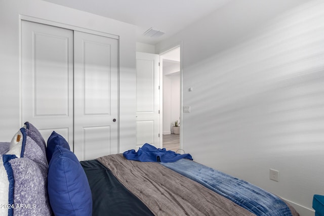 unfurnished bedroom with wood-type flooring and a closet