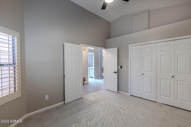 unfurnished bedroom featuring a closet, high vaulted ceiling, and ceiling fan