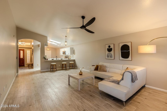 living room featuring ceiling fan, sink, and light hardwood / wood-style flooring