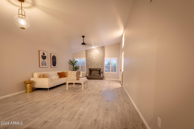 living room featuring a large fireplace, light wood-type flooring, and lofted ceiling