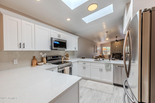 kitchen featuring white cabinetry, kitchen peninsula, sink, and appliances with stainless steel finishes