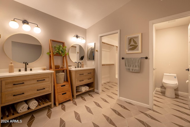 bathroom with tile patterned floors, vanity, toilet, and lofted ceiling