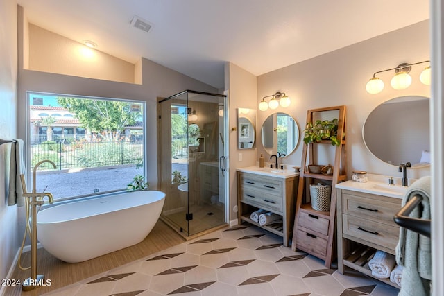 bathroom featuring plus walk in shower, vanity, lofted ceiling, and tile patterned flooring