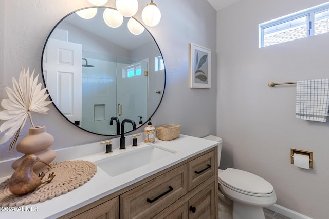 bathroom featuring a shower with door, vanity, and toilet