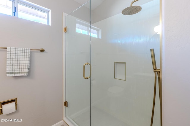 bathroom featuring a shower with door