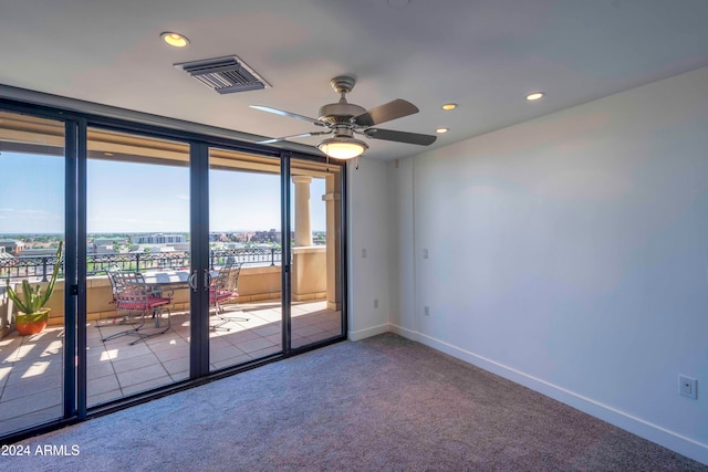 carpeted spare room with ceiling fan