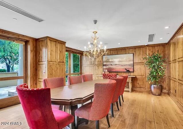 dining space with wooden walls, light hardwood / wood-style floors, and plenty of natural light