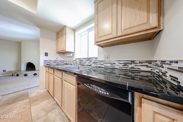 kitchen with a sink, decorative backsplash, dishwasher, and light brown cabinetry