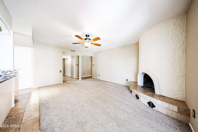 unfurnished living room with visible vents, light colored carpet, a fireplace, and a ceiling fan