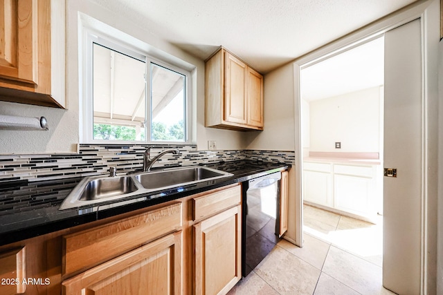 kitchen featuring dishwasher, dark countertops, a sink, and light brown cabinetry