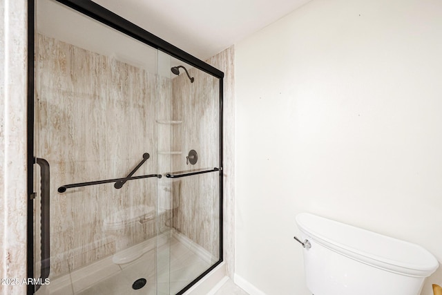 full bath featuring a shower stall and toilet