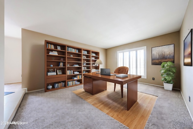 carpeted home office featuring baseboards