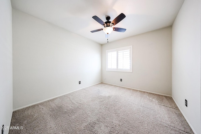 spare room featuring carpet flooring, baseboards, and a ceiling fan