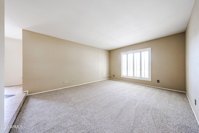 unfurnished room with baseboards and carpet floors