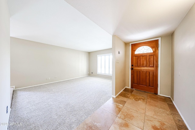 entrance foyer featuring baseboards and light carpet