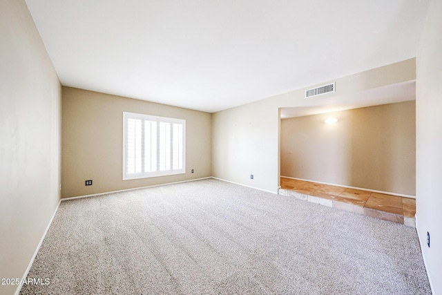 carpeted spare room featuring visible vents and baseboards