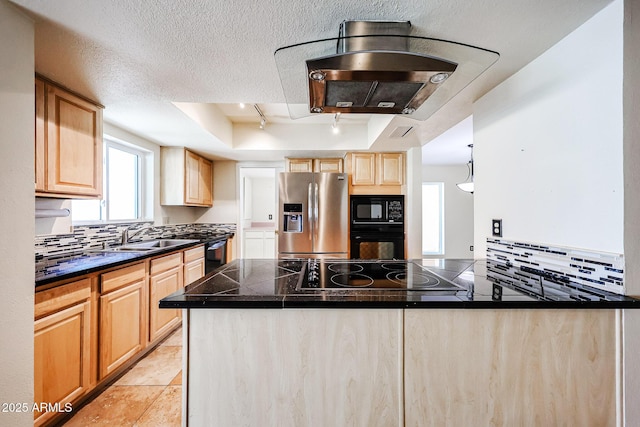 kitchen with tile countertops, light brown cabinets, a tray ceiling, a sink, and black appliances