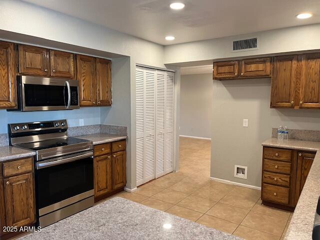 kitchen featuring stainless steel appliances and light tile patterned floors