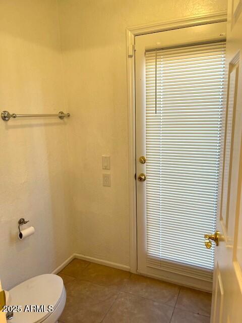 bathroom featuring toilet and tile patterned flooring