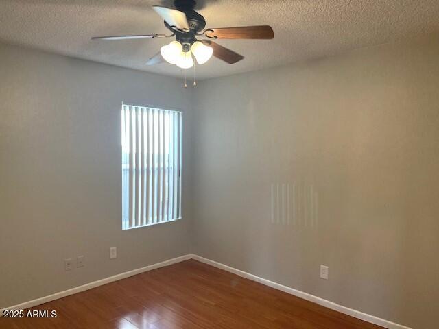 empty room featuring hardwood / wood-style floors, a textured ceiling, and ceiling fan